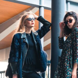 woman in blue denim jacket standing beside woman in black and white floral long sleeve shirt
