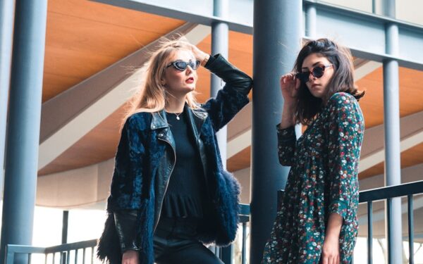 woman in blue denim jacket standing beside woman in black and white floral long sleeve shirt