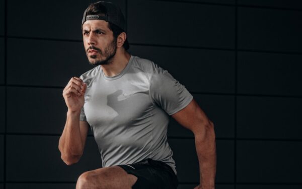 man in white crew neck t-shirt and black shorts sitting on floor