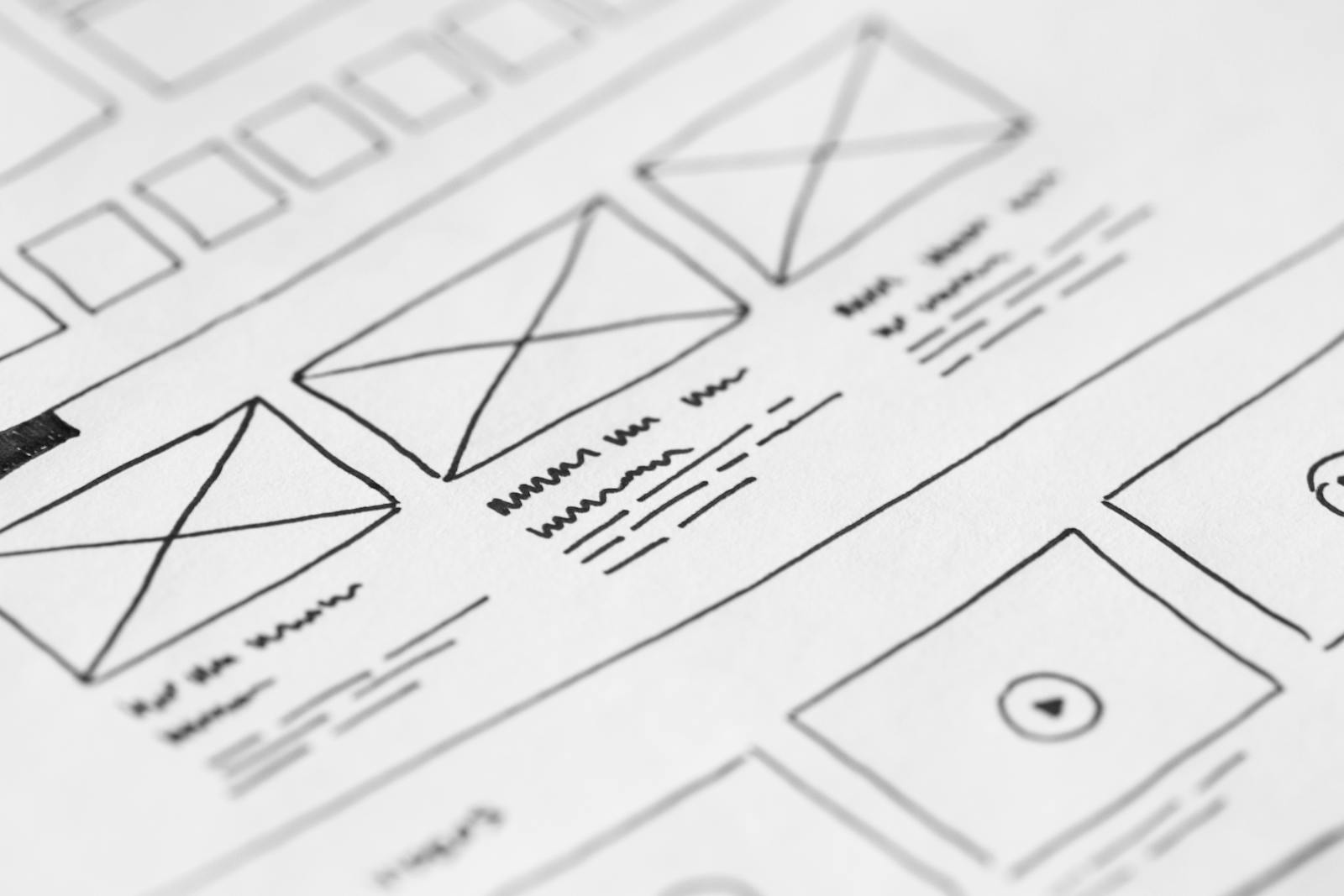 A detailed sketch of a website wireframe featuring various layout elements and placeholders for images and text.